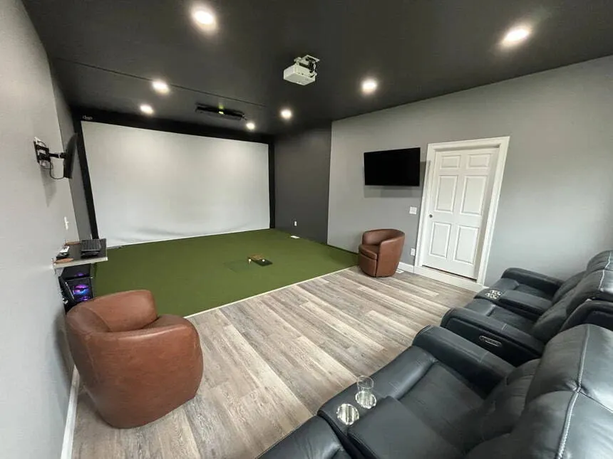 Basement golf simulator room with theater seating — see builds like it at the All Seasons Kansas City showroom