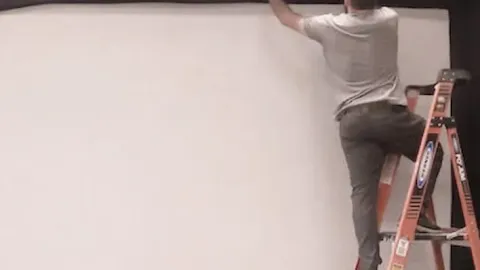 Installer mounting the impact screen during a golf simulator installation
